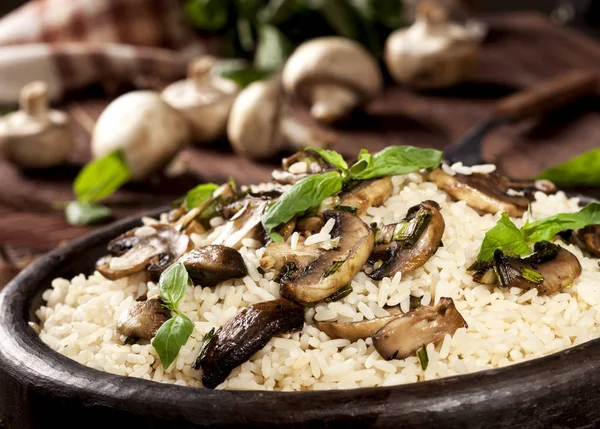 Cooked white rice with mushroomsin a bowl on wooden background.