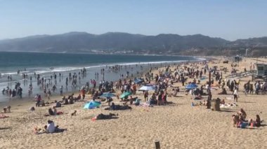 Bir grup insan günü plajda geçiriyor..