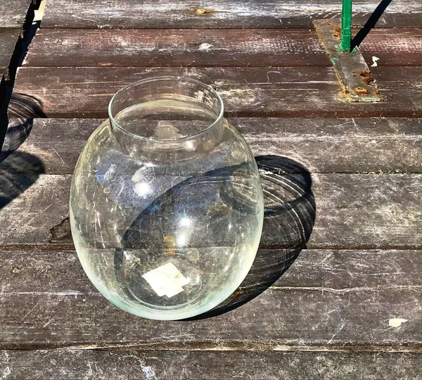 Cam kavanoz masada. Güneşin altında otururken.