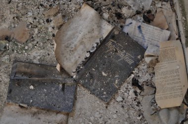 Eski kitaplar tozla kaplı terk edilmiş bir evde yerde yatıyor.