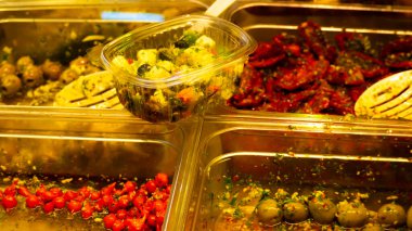 Almanya 'daki İtalyan pazarından yeni sarılmış zeytinler çeşitli antipastalarla çevrelenmiştir (işlemeli tatlı biber ve zeytin)