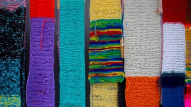 Yakından bakınca farklı desenlere ve renklere sahip örülmüş eşarplar