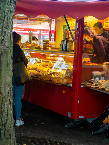 Karlsruhe, Almanya - 21.10.2019: Sonbahar sezonunda marketten taze yiyecek alan kişi, tipik Alman pazarı