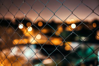 Gece şehir bokeh arka plan ile Zincir bağlantı çit