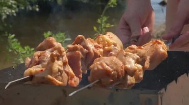  Bir adam ateşte eti şişe geçirir. Doğada barbekü.