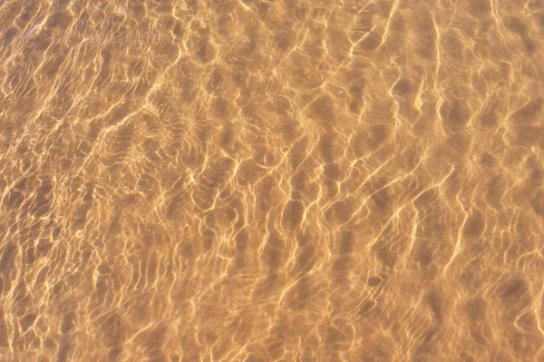 The glare of the sun on the water near the shore. Photos on the beach on a Sunny day