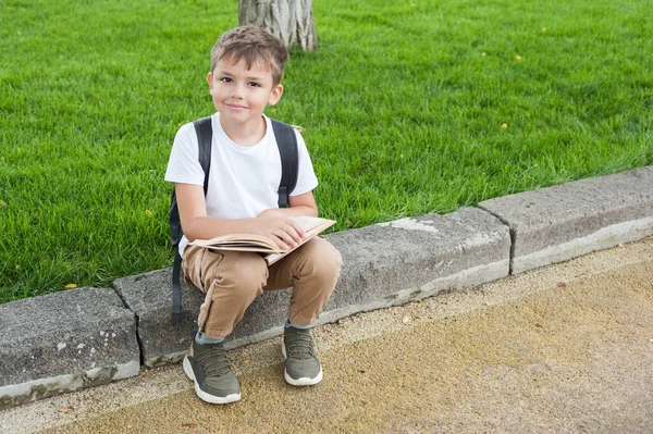 Ein Junge Europäischen Aussehens Weißem Shirt Mit Rucksack Liest Park — Stockfoto