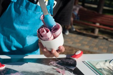  Dondurma satıcısı kupaya koyar. Sokak şekerleri