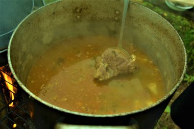 açık ateşte pişirilen et ile sarı çorba