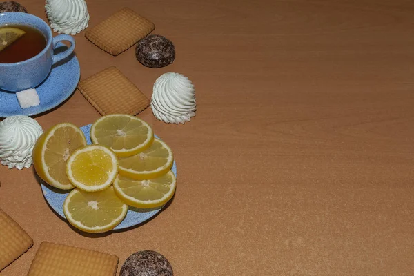 Limon, hatmi, zencefilli kurabiye ve çay ahşap zemin ile tanımlama