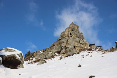 bulutlu mavi gökyüzü bir arka plan üzerinde karla kaplı kayalıklar