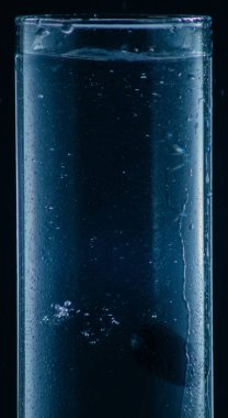 siyah bir arka plan üzerinde bir bardak su