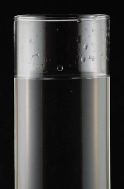 siyah bir arka plan üzerinde bir bardak su