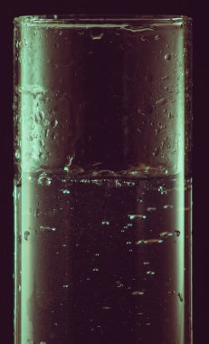 siyah bir arka plan üzerinde bir bardak su