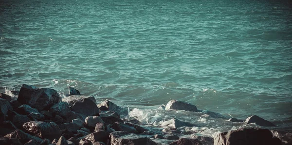 Junto al lago con piedras y agua azul — Foto de Stock