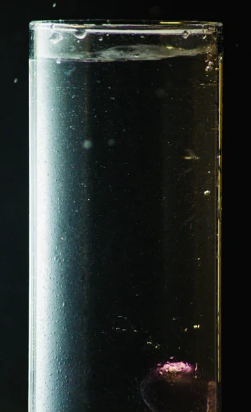 siyah bir arka plan üzerinde bir bardak su