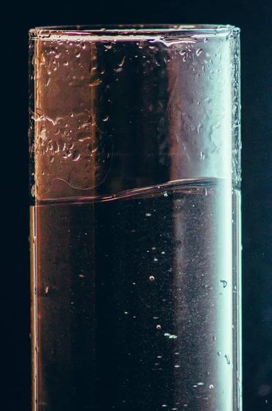 siyah bir arka plan üzerinde bir bardak su