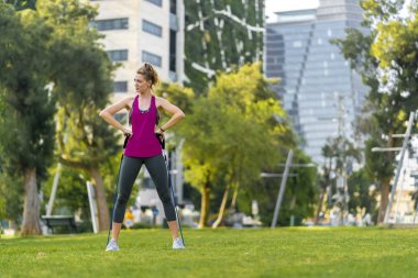 Genç sporcu bir şehirde çim üzerinde egzersizleri performans 