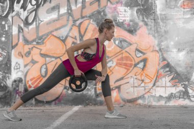 Genç sporcu bir şehirde çim üzerinde egzersizleri performans 