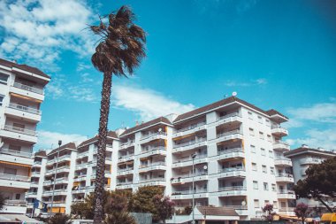 Sıcak güneşli bir günde avuç içi ile otel binası. Tatil ve tatil konsepti.