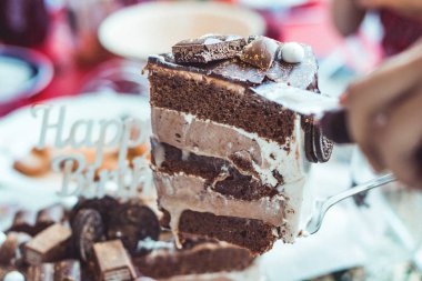 Mutlu Yıllar tabelası ile Çikolatalı Kek pastadan dilimlenmiş büyük bir porsiyon servis ediliyor. Kutlama ve tatil konsepti.