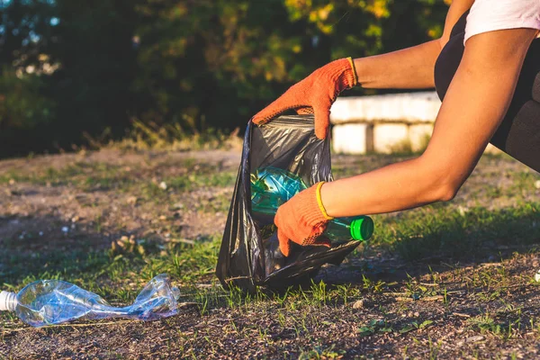 Garbage bottles picked up and thown into a trash bag. Plastic and food waste concept. Clean planet Earth, collect garbage, avoid pollution, save environment. — Stock Photo, Image