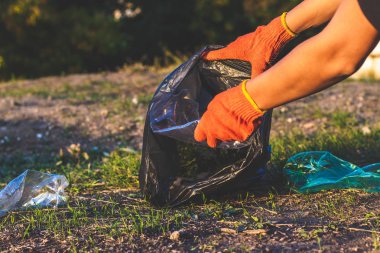 Çöp şişeleri toplanıp çöp torbasına sildi. Plastik ve gıda atıkları konsepti. Dünya'yı temizleyin, çöp leri toplayın, kirliliği önleyin, çevreyi kurtarın.