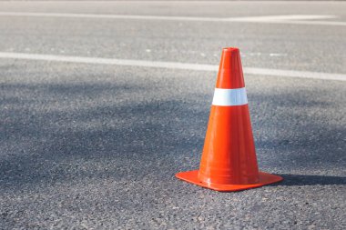 Asfalt yolda beyaz çizgili kırmızı turuncu koni. Sürücü güvenliği ve yapı kavramı.
