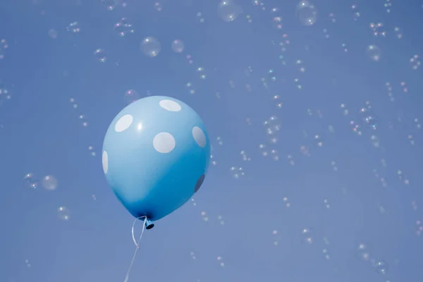 Gökyüzünde uçan mavi balon ve sabun köpükleri. Arka plan ve kazanan konsept. — Stok fotoğraf
