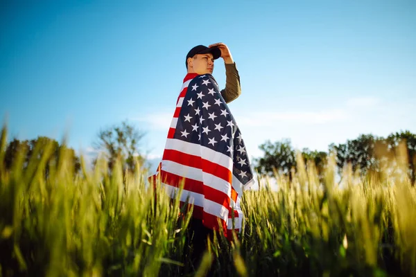 Young Man Wearing Green Shirt Cap Stands Wrapped American Flag — Stock Photo, Image