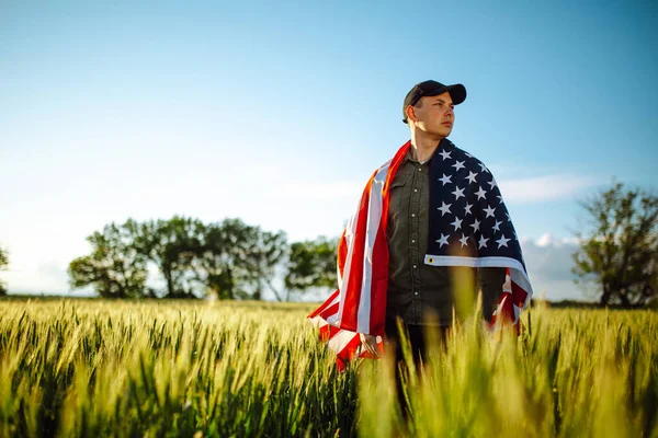 Молодой Человек Зеленой Рубашке Кепке Стоит Завернутый Американский Флаг Зеленом — стоковое фото