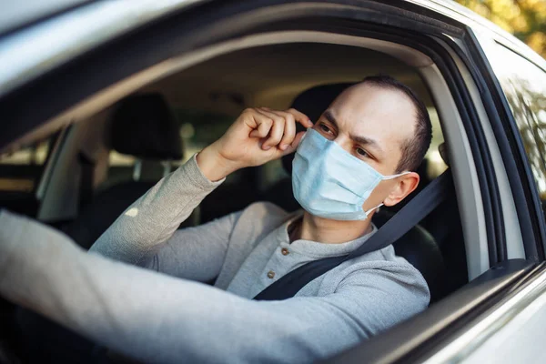 Hombre Conduce Coche Ajusta Máscara Médica Durante Brote Coronavirus Taxista — Foto de Stock
