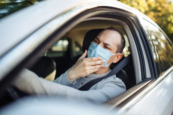 Hombre Conduce Coche Ajusta Máscara Médica Durante Brote Coronavirus Taxista — Foto de Stock