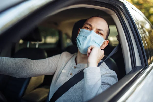 Hombre Conduce Coche Ajusta Máscara Médica Durante Brote Coronavirus Taxista — Foto de Stock