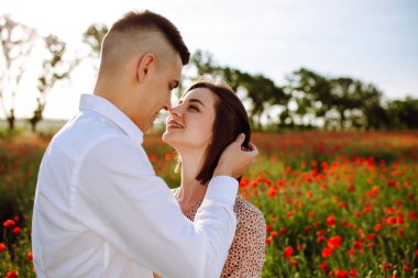 Romantik genç çift kırmızı afyon tarlasında sarılıyor. Sevgi dolu erkek ve kız ayağa kalkar, sarılır ve öpüşürler birbirlerine duygularını gösterirler. Özgürlük, düğün, aile ve aşk kavramı