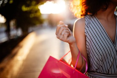 Mutlu kız butik dükkanının yanında elinde birkaç çanta ile duruyor. Genç bayan satış sezonunda makul bir fiyata yeni kıyafetler almaktan memnun. Alışveriş, indirim, para harcama konsepti