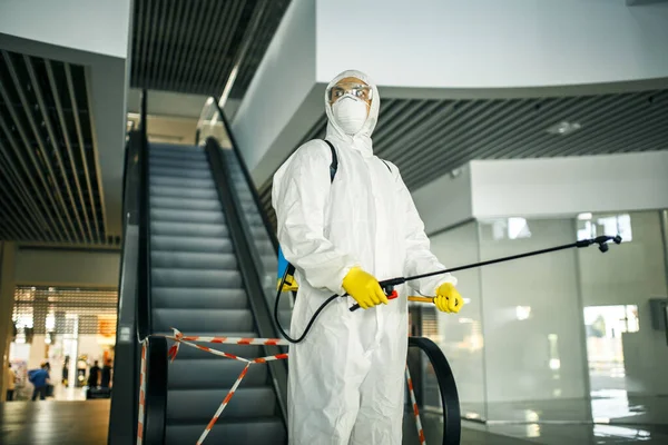 무의미 쇼핑몰의 에스컬레이터 근처에 스프레이를 사람의 장소를 청소하는 봉사자 19를 — 스톡 사진