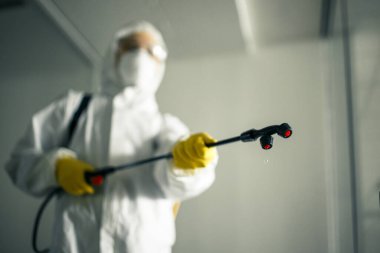 Hijyenik işçiler boş bir iş merkezini antiseptik sıvıyla ilaçlayarak kovid 19 'un yayılmasını engelliyor. Alışveriş merkezini temizleyen dezenfekte kıyafeti giyen bir adam. Hiç kimse, sağlık, izole konsept