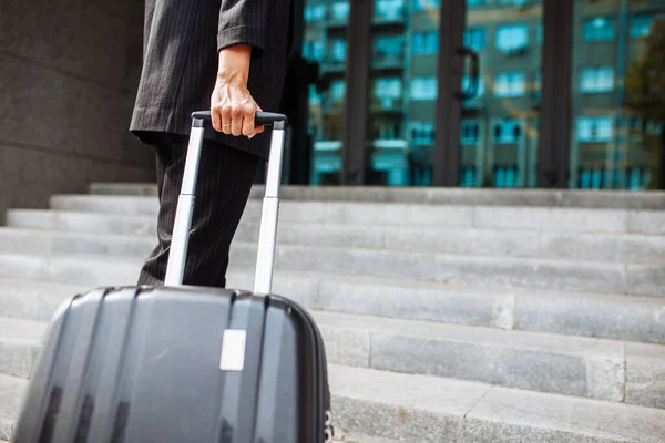 Young business woman walking up the staircase with a suit ready to check in at hotel\'s reception. Beginning of a business trip for a professional worker. Work and travel concept