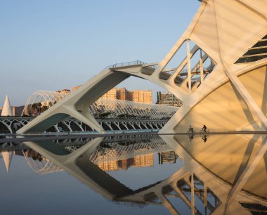 Şafakta iki bisikletçi Valencia Sanat Şehri 'nde yürüyor. Seyahat Konsepti