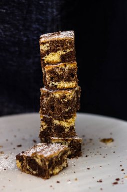 Kulede üzerine şeker serpiştirilmiş siyah beyaz çikolatalı kek. Yiyecek konsepti