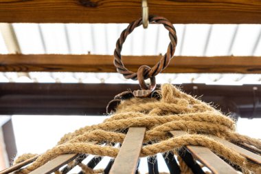 Kafesi metal halka tutuyor. Metal çubuklar örülmüş halat.