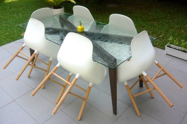 Bir cam masa ve altı beyaz sandalye