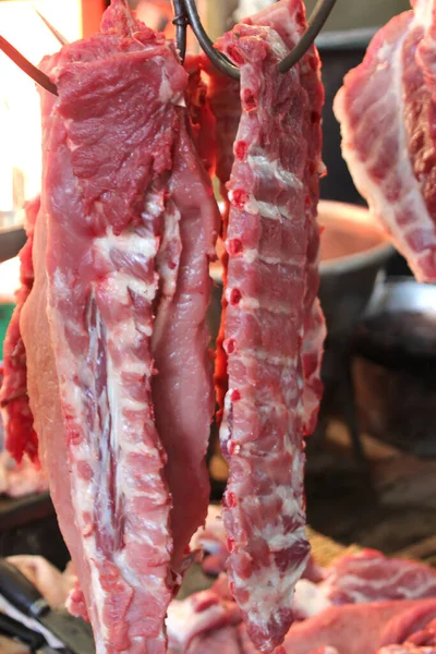 1 Свежее мясо свинины висит на крючках — стоковое фото