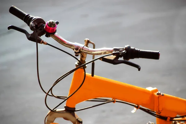 콘크리트 길 배경에 있는 핸들과 노란 자전거의 뼈대 — 스톡 사진
