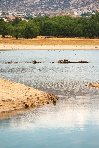Manzanares el Real rezervuar ve arka planda köy ve dağlar 