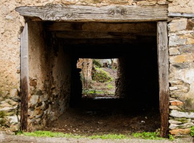 Ahşap bölümleri ve taşla çevrili bir blok olarak kullanılan bir evin içine erişim