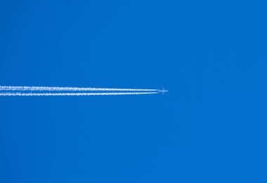 Beyaz çizgiler uçaklar yapay bulutlar gibi geride bırakır. Mavi gökyüzü arka planı