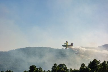 Robregordo, Madrid, İspanya; 07 / 14 / 2019: Bir orman yangını sırasında deniz uçağı suya indirme