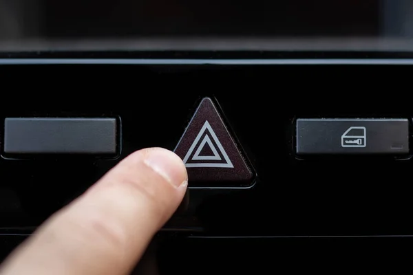 Hand ready to press the warning button of a car, Button off